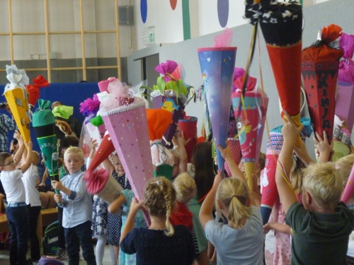 Kinder halten ihre Schultüte in die Luft